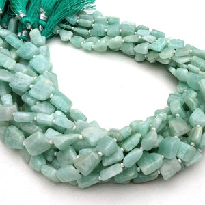 May include: A strand of light green aquamarine gemstone beads. The beads are faceted and have a slightly irregular shape. The beads are strung on a clear thread and are ready to be used for jewelry making.