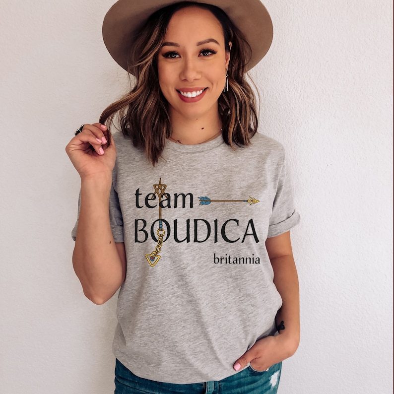 Pu&ograve; includere: Maglietta grigia con il testo "team BOUDICA britannia" e una grafica di una freccia con un design a buco della serratura.