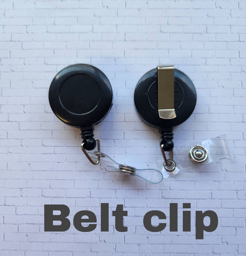 May include: Black retractable badge reel with a belt clip. The reel has a clear strap and a metal button.