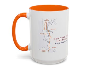 May include: A white ceramic mug with a bright orange handle and interior. The exterior features a map of the New York City Marathon route with the text New York City Marathon November 1, 2020, labelling Manhattan, Brooklyn, Queens, The Bronx, and Staten Island.