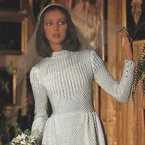 May include: A vintage crochet wedding dress pattern. The pattern features a long-sleeved dress with a fitted bodice and a flowing skirt. The dress is made with a delicate lace pattern and has a simple, elegant design.
