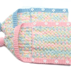 May include: Two crocheted baby hats with pom-poms. The hats are made with a multi-colored yarn in shades of blue, pink, and yellow. The hats have button closures.