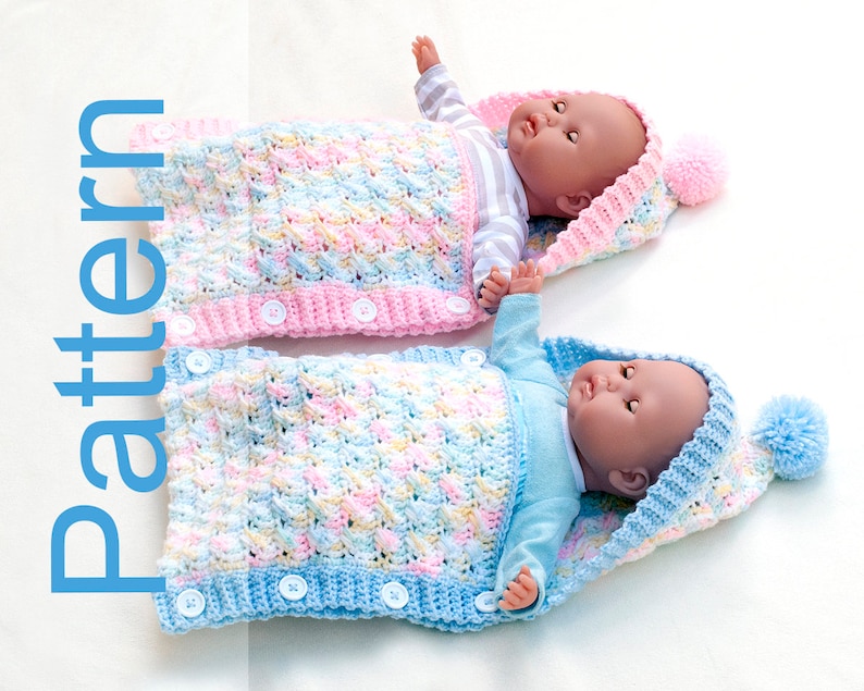 May include: Two crocheted baby sleeping bags with hoods and pom-poms. One is pink and white, the other is blue and white. Both have buttons down the front.