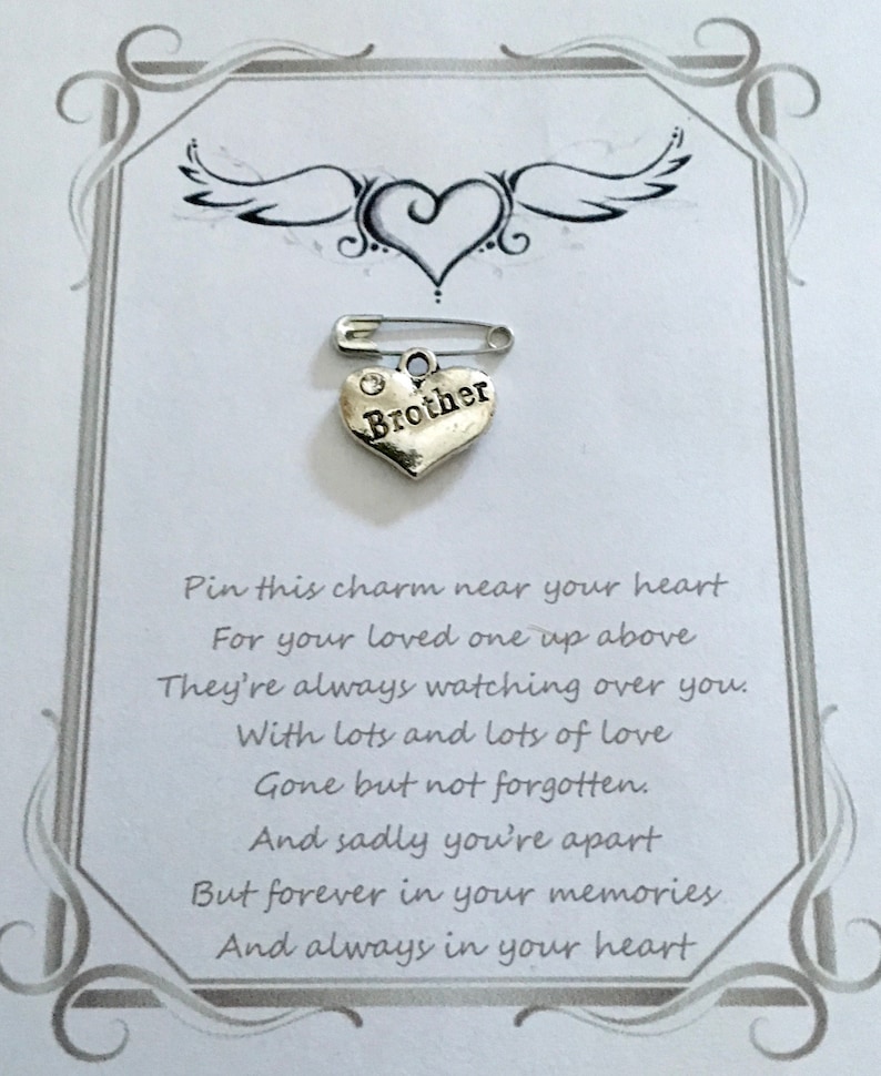 May include: A silver heart-shaped charm with the word "Brother" on a safety pin, set against a white card with a decorative border. The card includes a poem about remembrance and love.