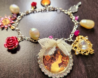 May include: Silver charm bracelet featuring various charms, including a cameo pendant, pearls, a pink flower, and a red rose. The bracelet has a vintage aesthetic with a mix of textures and colors.