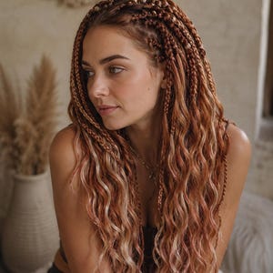May include: A woman with long, braided hair in shades of brown and blonde. The braids are styled with a mix of straight and wavy sections. The hair is accessorized with small gold beads. The woman is looking to the side.