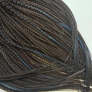 Midnight Threads: trenzas bohemias, extensiones de color marrón oscuro con sutiles detalles azules.