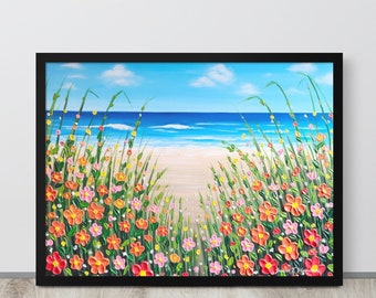 Puede incluir: Pintura enmarcada de una escena de playa. La obra representa un camino arenoso que conduce al océano bajo un cielo azul con nubes. Flores coloridas y hierba alta enmarcan el camino. La pintura está en un marco negro.