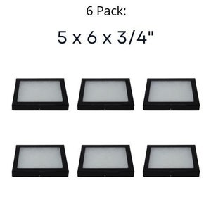 Op de afbeelding: Zes zwarte vierkante displaykasten met een witte binnenkant. De kasten zijn 12,7 cm x 15,2 cm x 1,9 cm. De tekst "6 Pack: 5 x 6 x 3/4" staat boven de kasten.
