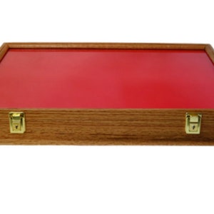 May include: A wooden display case with a red felt lining and brass clasps. The case is made of light brown wood and has a rectangular shape.