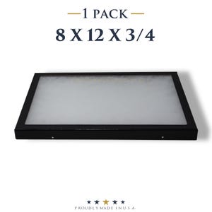 May include: A black rectangular display case with a clear top. The dimensions are 8 x 12 x 3/4 inches. The text "- 1 PACK -" is above the dimensions. The text "PROUDLY MADE IN U.S.A." is below the display case.