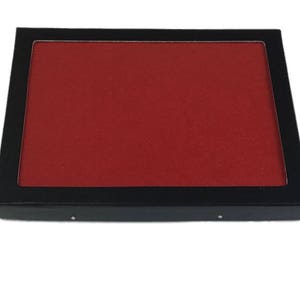 May include: A black tray with a red velvet lining. The tray is rectangular and has a raised edge.