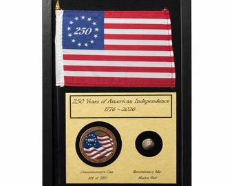 Exhibición del 250 aniversario de Estados Unidos con moneda, bandera y artefacto de la Guerra de Independencia (1776-2026) en vitrina.