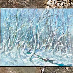 Puede incluir: Una pintura que representa una escena de bosque nevado con &aacute;rboles desnudos y un cielo azul. La pintura est&aacute; firmada "Joukkiel Jou" y fechada "2023".