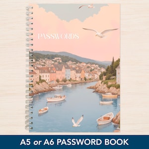 May include: A spiral-bound password book with a coastal illustration. The cover shows a harbour scene with boats, buildings, and seagulls under a pastel sky. The word "PASSWORDS" is printed on the cover. The text "A5 or A6 PASSWORD BOOK" is at the bottom.