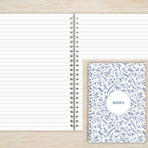 May include: A white spiral bound notebook with lined pages and a blue floral design on the cover. The cover has a circle with the word "notes" inside.