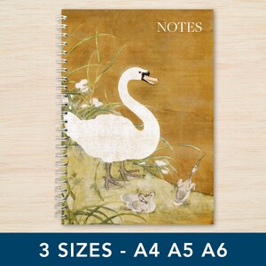 May include: A spiral-bound notebook with a mustard-yellow cover featuring a white swan and two cygnets among green reeds. The word NOTES is printed in white in the top right corner. The notebook is available in three sizes: A4, A5, and A6.