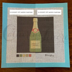 May include: Two pieces of white Aida cloth with a green, yellow, and red champagne bottle design printed on them. The cloth is labeled "13 COUNT (CT) MONO CANVAS" and "18 COUNT (CT) MONO CANVAS".