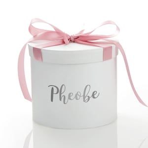 Caja de regalo redonda blanca personalizada con lazo de cinta rosa bebé