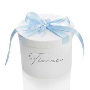 Caja de regalo redonda blanca personalizada con lazo de cinta azul bebé