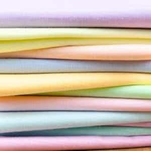 May include: Stack of pastel colored fabric swatches in shades of pink, yellow, blue, and green.