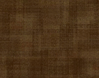 May include: A dark brown fabric with a visible crosshatch texture. A white ruler is positioned along the top edge, showing measurements in inches from 1 to 11, indicating the scale of the woven pattern on the textile surface.