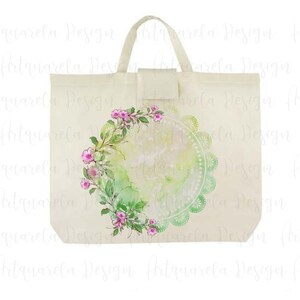 K&ouml;nnte beinhalten: Eine wei&szlig;e Canvas-Tragetasche mit einem gr&uuml;n-wei&szlig;en Aquarelldesign, das einen Blumengirlanden und einen Spitzenkreis zeigt. Das Design ist mittig auf der Tasche platziert.