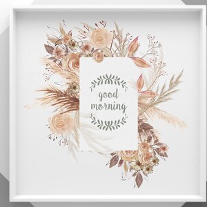 Op de afbeelding: Een ingelijste print met een bloemstuk in zachte perzik-, bruin- en groentinten. Het ontwerp bevat rozen, pampasgras en andere gedroogde bloemen rondom een witte rechthoek met de woorden "good morning".
