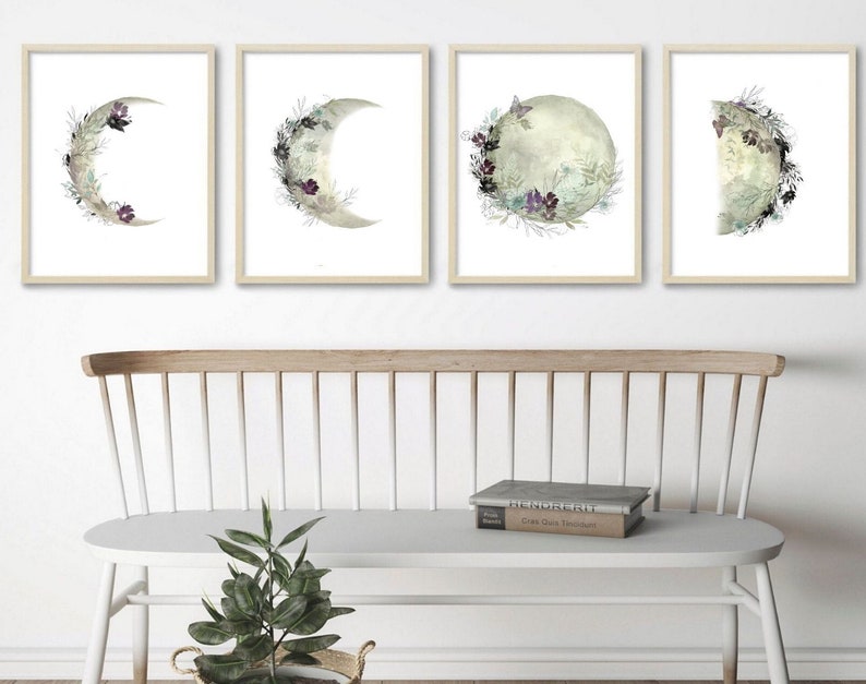 May include: Set of four framed prints featuring watercolor illustrations of crescent moons with floral details. The moons are in various phases, with some featuring a butterfly.