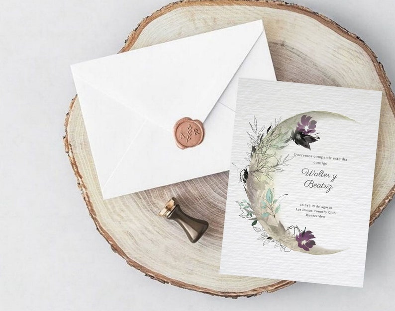 May include: A wedding invitation with a watercolor illustration of a crescent moon with floral details. The invitation is for Walter and Beatriz, and it states the date and location of the wedding. The invitation is on a wooden surface with a white envelope and a wax seal.