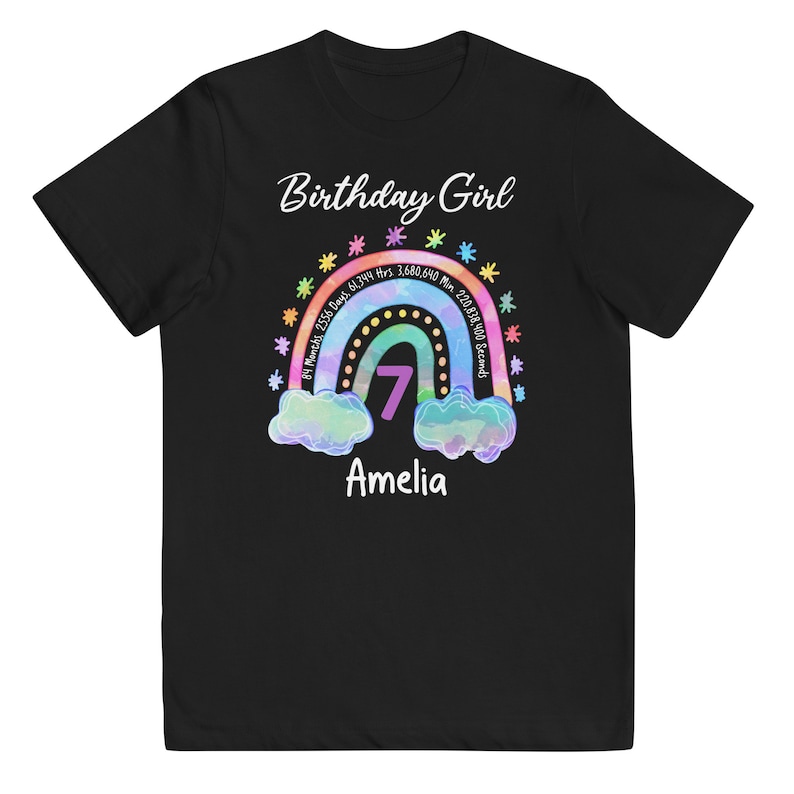 May include: Black t-shirt with a rainbow design and the text "Birthday Girl" and "Amelia". The rainbow has a number 7 in the center and text around it that reads "81 Months, 2556 Days, 61,344 Hrs, 3,680,640 Min, 220,838,400 Seconds".