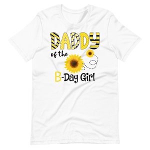 Peut inclure: T-shirt blanc avec l'inscription "DADDY of the B-Day Girl" en jaune et noir. Le motif comprend des tournesols et des pointill&eacute;s. Un t-shirt joyeux pour une f&ecirc;te d'anniversaire.
