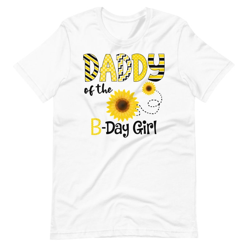 Peut inclure: T-shirt blanc avec l'inscription "DADDY of the B-Day Girl" en jaune et noir. Le motif comprend des tournesols et des pointill&eacute;s. Un t-shirt joyeux pour une f&ecirc;te d'anniversaire.