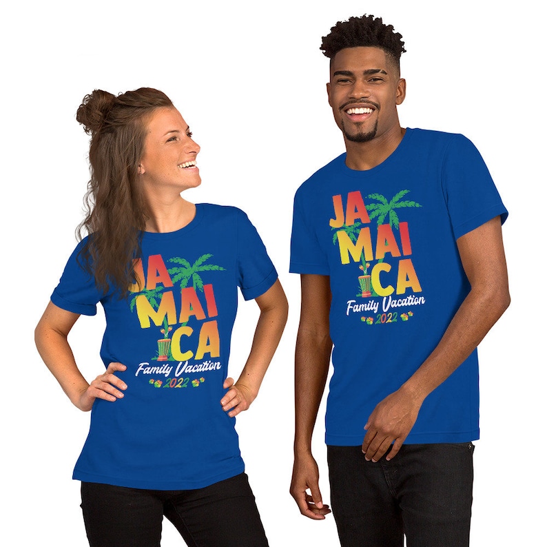 May include: Two people wearing blue t-shirts with a graphic design that says "Jamaica Family Vacation 2022" with palm trees and a cocktail shaker.