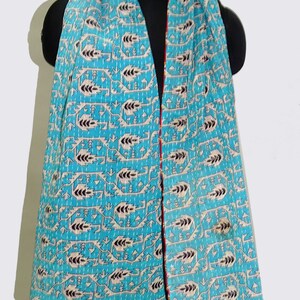 May include: A turquoise blue kantha scarf with a white and black geometric pattern. The scarf has a red and white trim and a frayed edge.