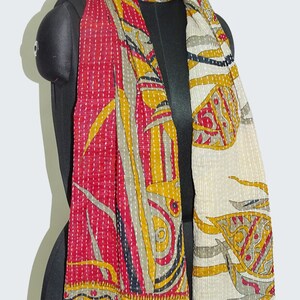 May include: A red, white and gold kantha scarf with a floral pattern. The scarf is quilted and has a fringed edge.