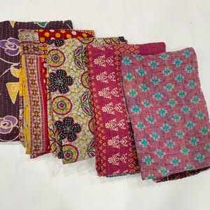 Pode incluir: Uma cole&ccedil;&atilde;o de pe&ccedil;as de tecido coloridas e estampadas. Os tecidos exibem uma variedade de designs, incluindo motivos florais, geom&eacute;tricos e paisley. A paleta de cores inclui tons de bord&ocirc;, amarelo e verde-azulado.