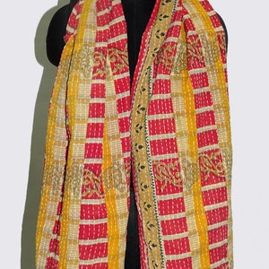May include: A yellow and red kantha quilted scarf with a geometric pattern. The scarf is made of cotton and has a fringed edge.