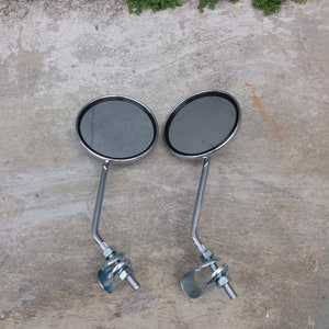 Peut inclure: Deux rétroviseurs de vélo en chrome avec des surfaces réfléchissantes rondes et des pinces réglables.