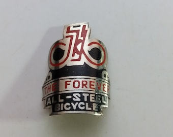 May include: A silver bicycle head badge with red and black lettering. The badge reads "The Forever All-Steel Bicycle".