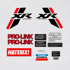May include: A set of black and red motorcycle decals with the text "XR 250L", "PRO-LINK", "HATESIX!" and "TEAM HONDA".