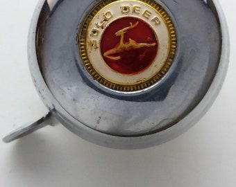 May include: A silver bicycle bell with a gold and white logo that says "Gold Deer" and features a red deer silhouette.