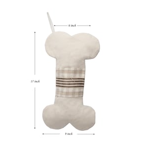 May include: A beige bone-shaped stocking with a brown and beige plaid band. The stocking is 17 inches tall, 6 inches wide at the top, and 9 inches wide at the bottom.