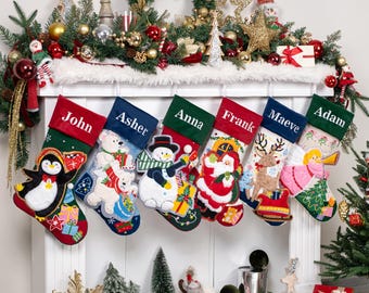 May include: A collection of six Christmas stockings with personalized names: John, Asher, Anna, Frank, Maeve, and Adam. Each stocking features a unique festive design, including a penguin, polar bears, a snowman, Santa Claus, a reindeer, and an angel.