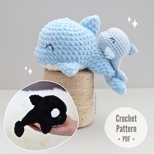 May include: Two crochet whales, one large and light blue, the other small and light blue, are displayed. A smaller inset shows a black and white crochet orca. The image includes the text "Crochet Pattern + PDF +".