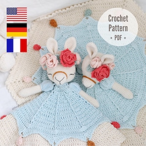 May include: A crochet pattern for two llama amigurumi toys with floral headbands. The pattern is available as a PDF download. The llamas are wearing blue and white crochet dresses and are sitting on a cream-colored crochet blanket.