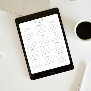 Pode incluir: Um calend&aacute;rio preto e branco na tela de um tablet, mostrando os meses de janeiro a dezembro de 2027.