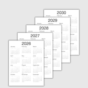 May include: A stack of five white paper calendars featuring the years 2026, 2027, 2028, 2029, and 2030. Each calendar displays twelve months from January to December with black text and numbers arranged in a grid format on a clean white background.