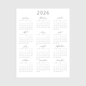 Peut inclure: Calendrier 2026 minimaliste imprimé sur papier blanc. Le calendrier présente un design simple avec le nom de chaque mois dans une police manuscrite. Les jours de la semaine sont abrégés et les chiffres sont clairement affichés.
