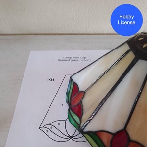 Puede incluir: Un patrón de pantalla de lámpara de vidrio tintado con un diseño de tulipán. El patrón está etiquetado con los números del 1 al 5 y el texto "x6". El texto "Lámpara con tulipán Patrón de vidrio tintado" también es visible. La imagen está etiquetada como "Licencia de aficionado" y "TiffanyAndiGifts On ETSY".